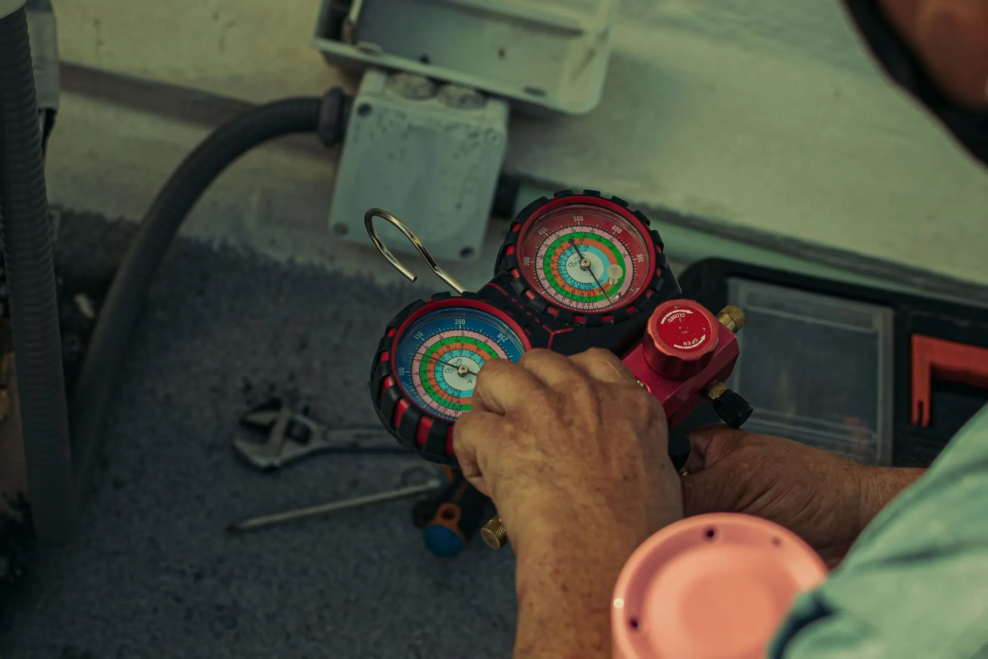 Technician reading refrigerant pressure gauges during an air conditioning service