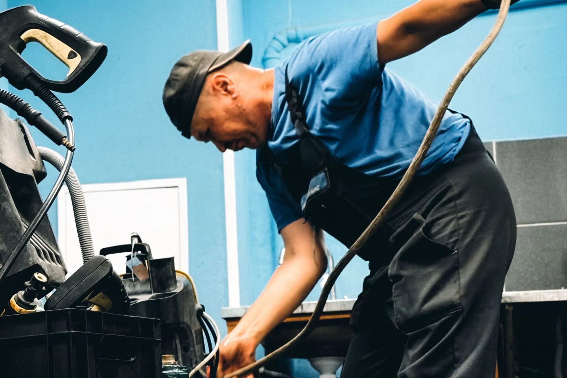 Plumber feeding a drain cleaning hose from a machine to clear blocked drains