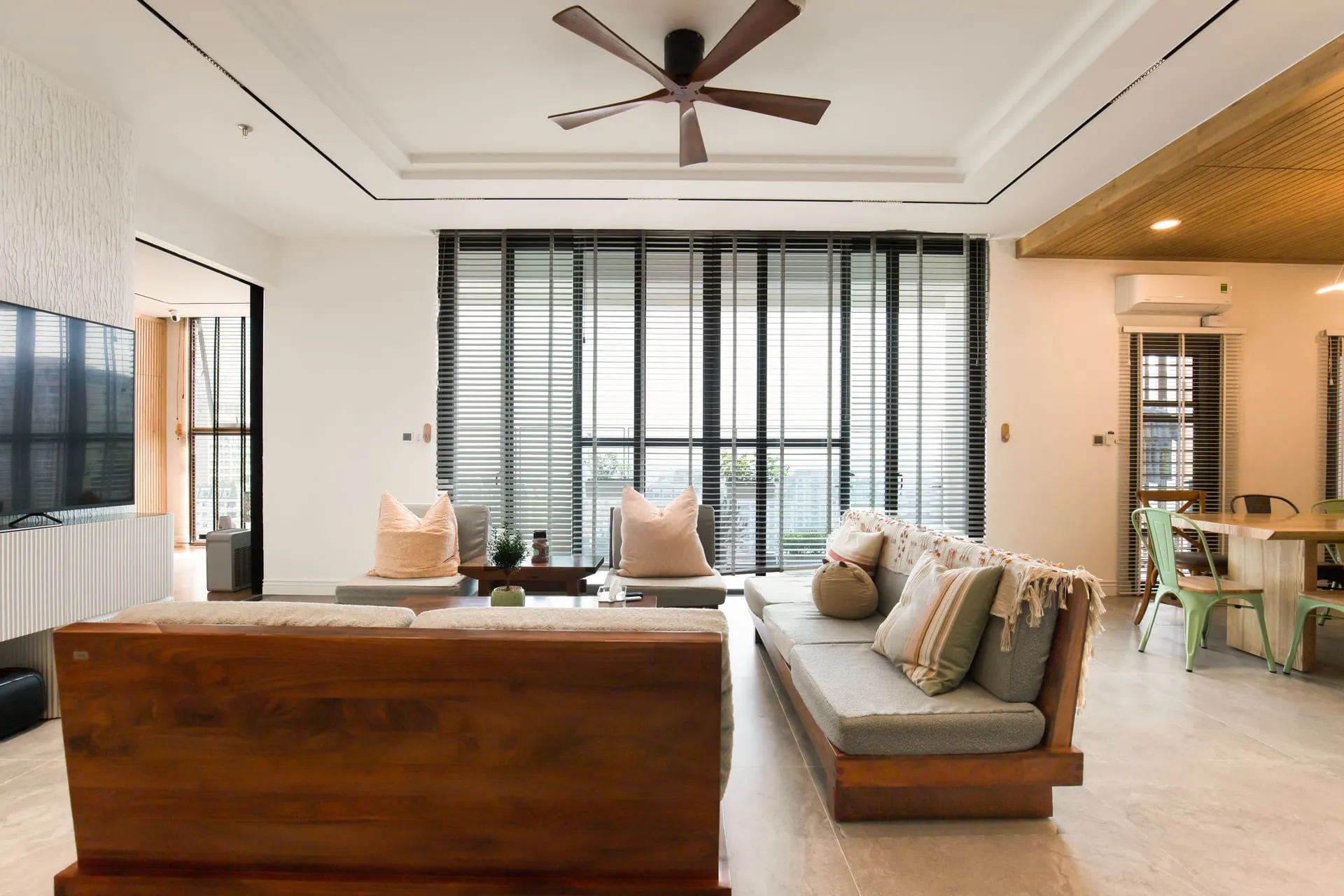 Dark timber ceiling fan installed above a bright, airy living room with sofas