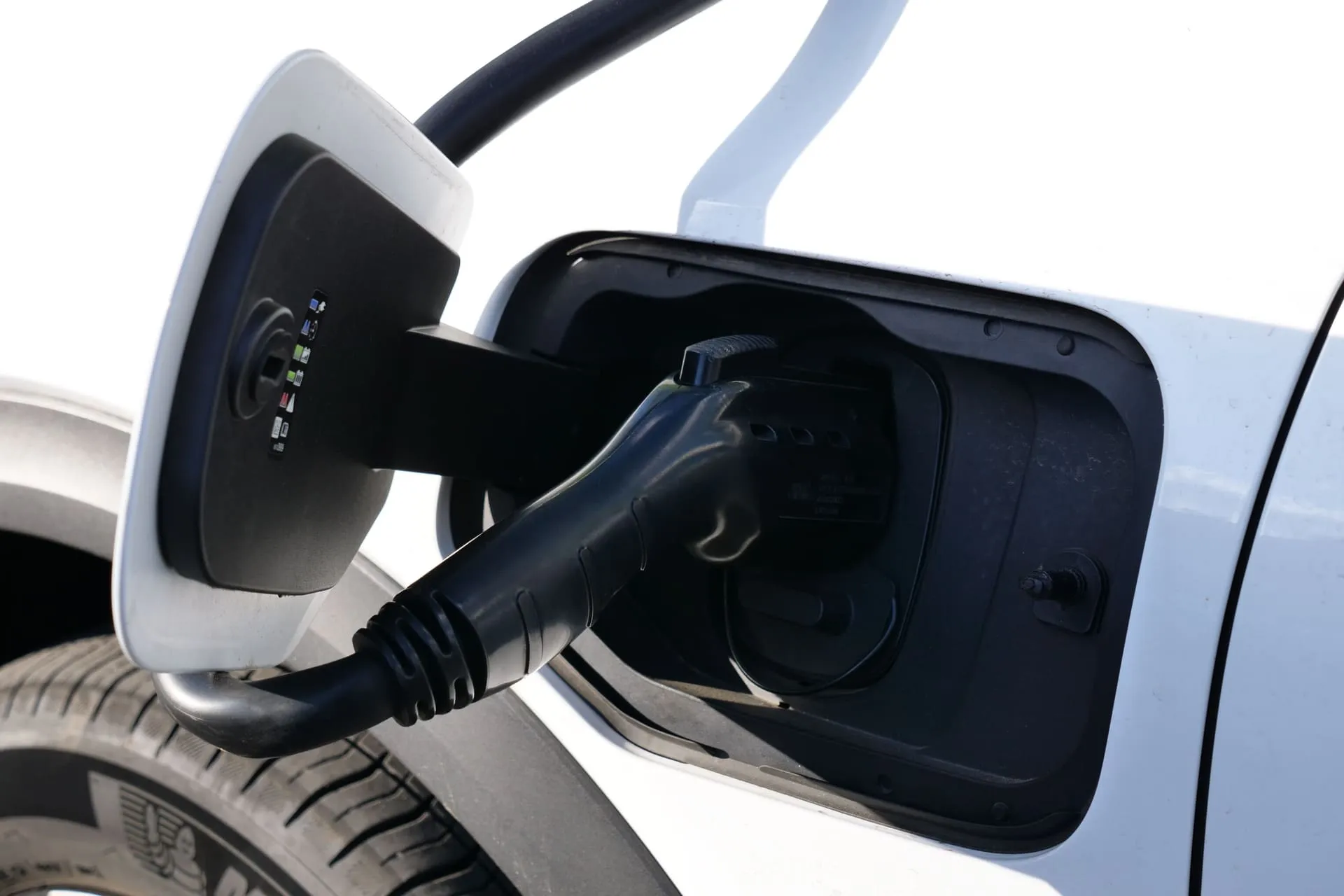 Charging cable plugged into an electric car, part of EV charger installation cost