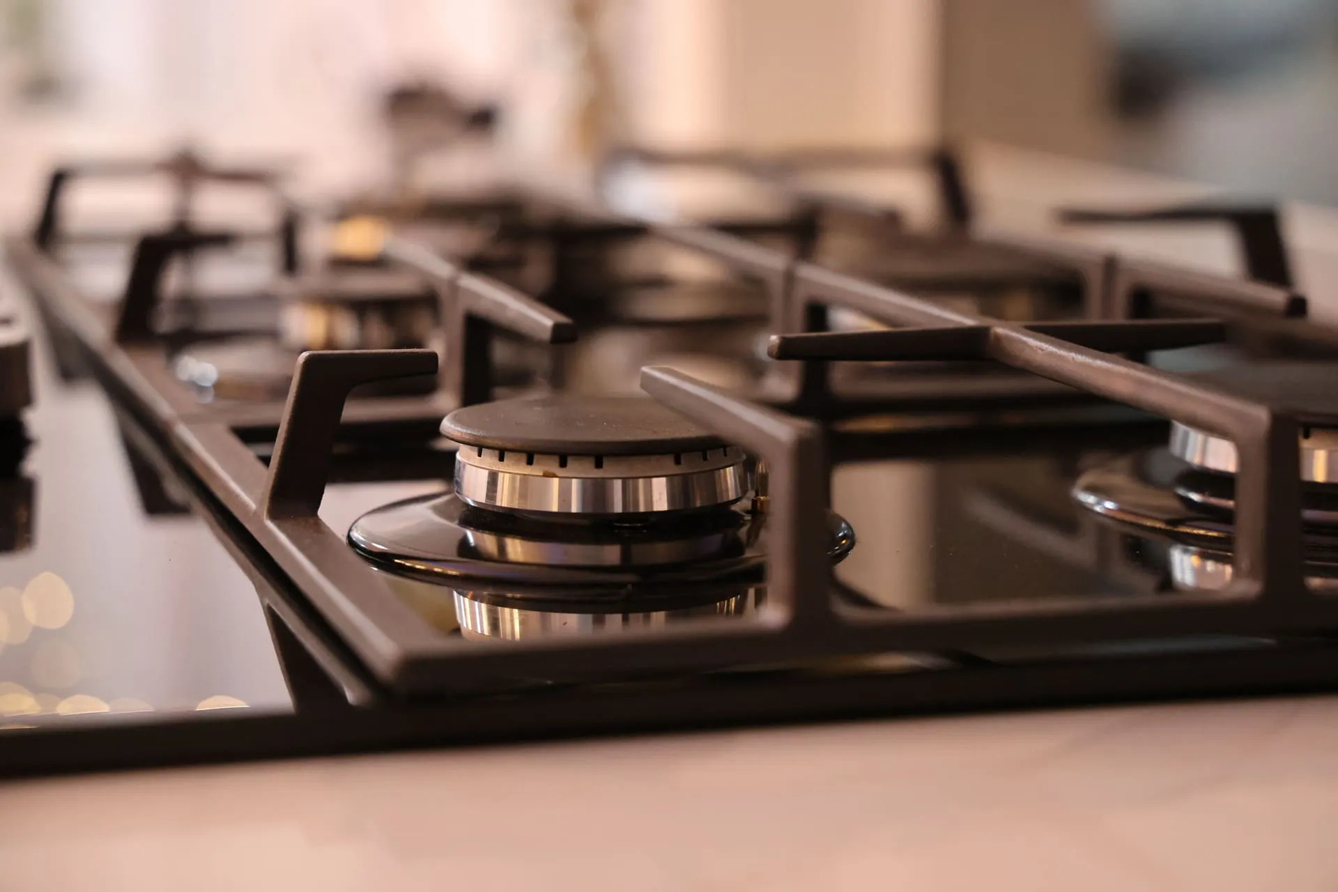 Close-up of a stainless steel gas cooktop burner fitted by a licensed gas fitter