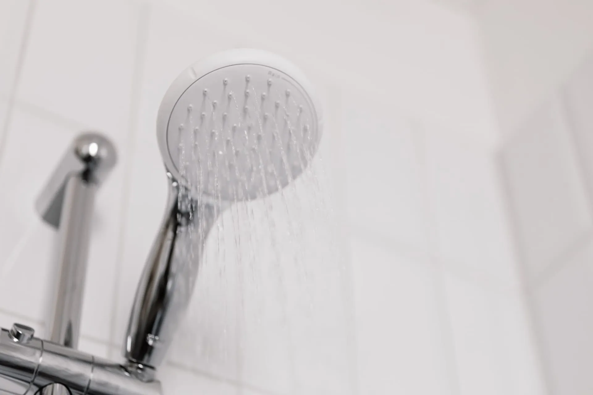 Handheld shower head with a weak spray, a sign of low water pressure in house