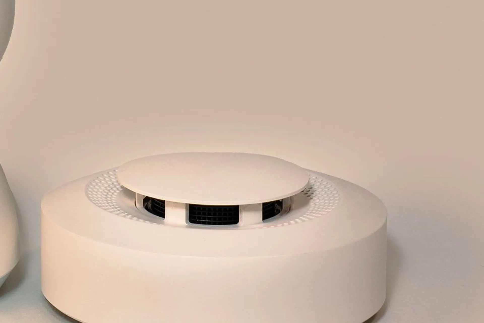 Close-up of a white photoelectric smoke alarm, ready for smoke alarm installation
