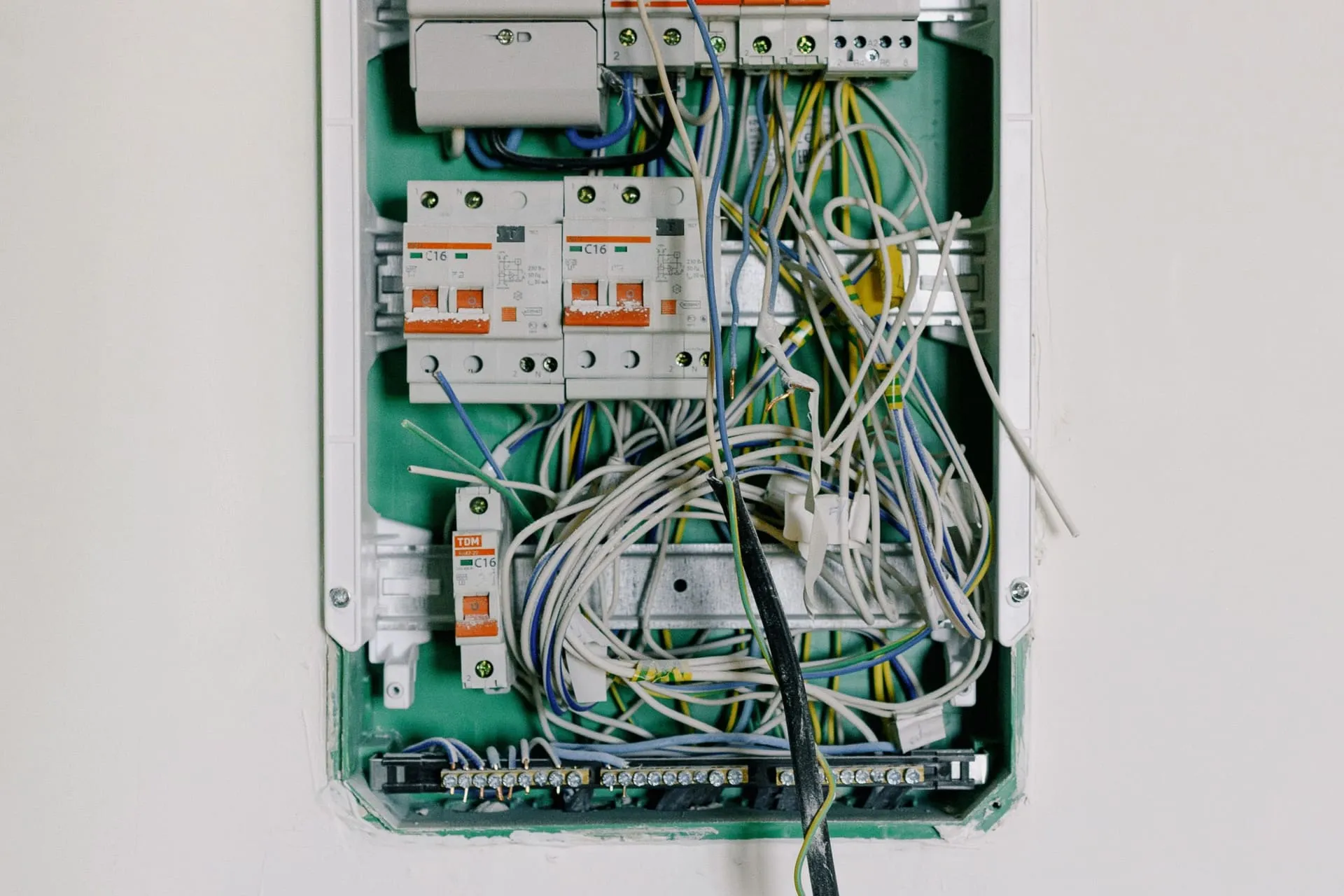 Open switchboard with circuit breakers and tangled wiring, the kind replaced in a switchboard upgrade
