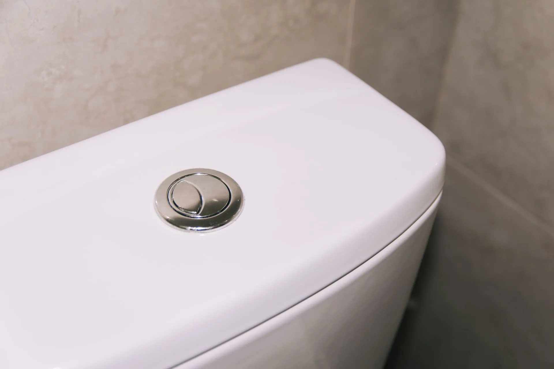 Dual flush button on a white toilet cistern when the toilet keeps running