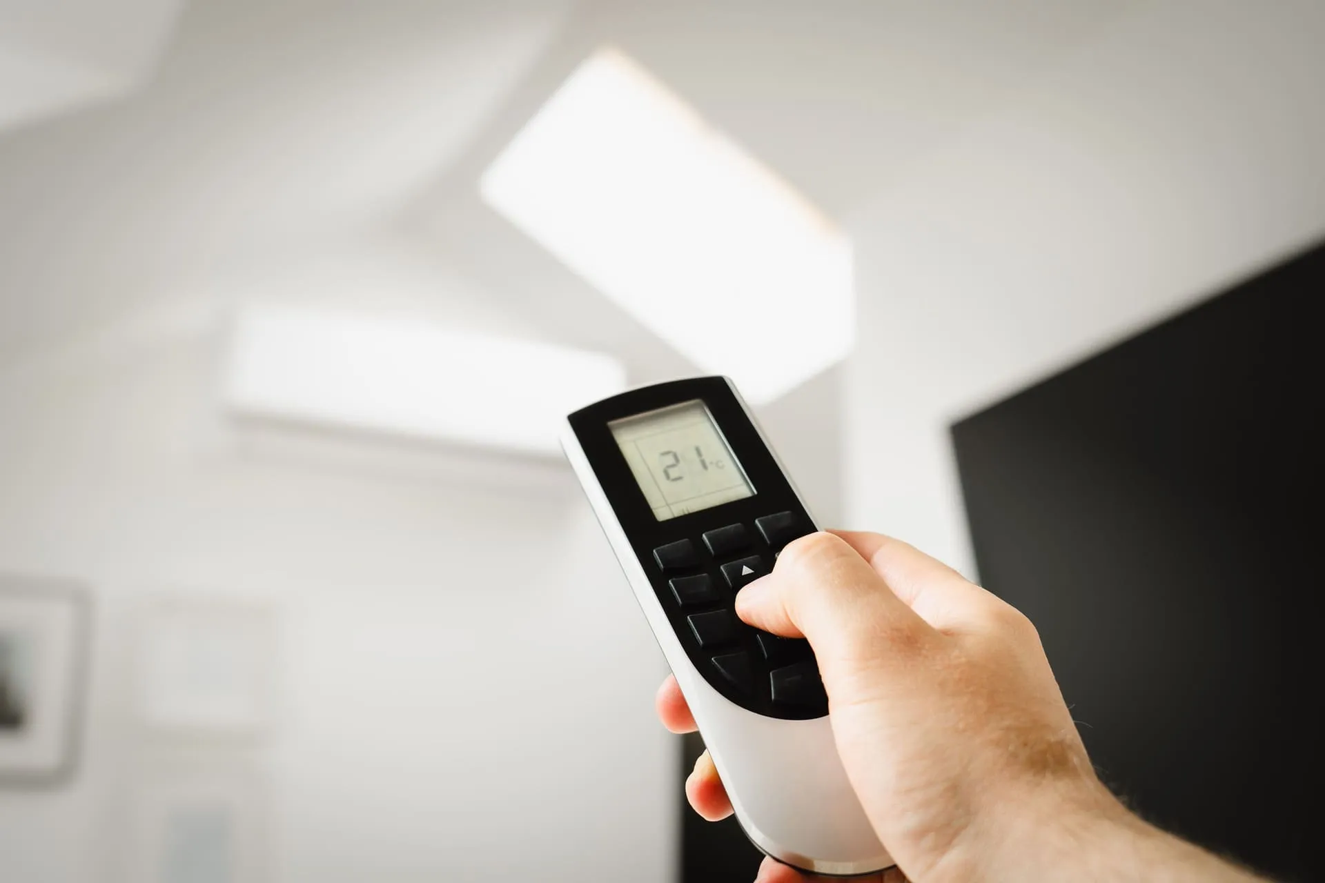 Air conditioner remote set to 21 degrees, used with an air conditioner size calculator